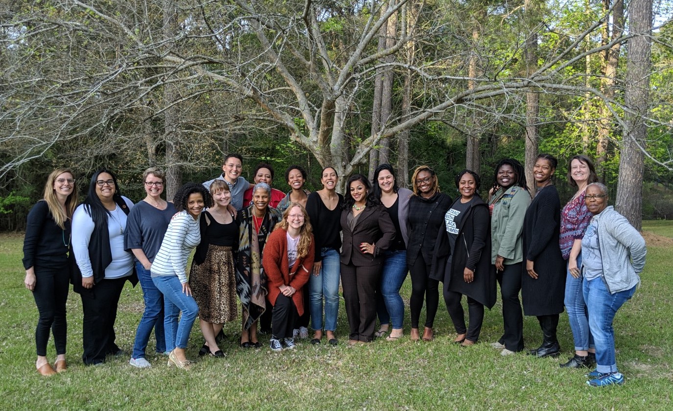 The full 2019-2020 cohort of HIVE stands outdoors in front of a big tree. 20 people of different ages, races, genders, body types, stand smiling at the camera.